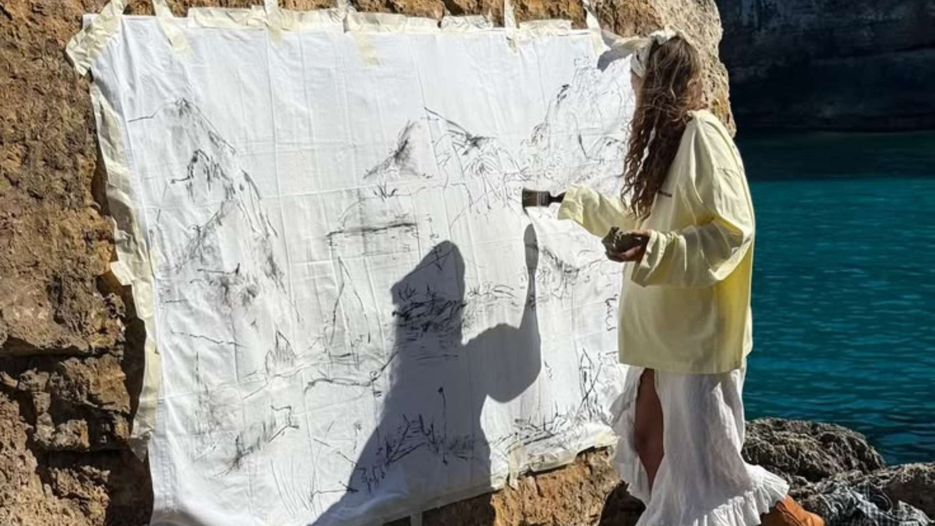 Woman painting on a canvas by the sea